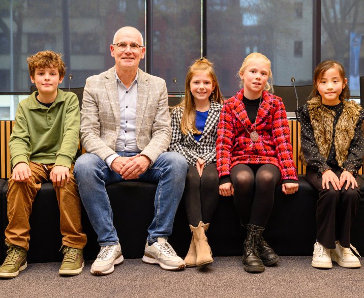 Jeugdcollege in raadzaal in Oss. Teun, wethouder Kees van Geffen, Vera, Julia en Aimee. 