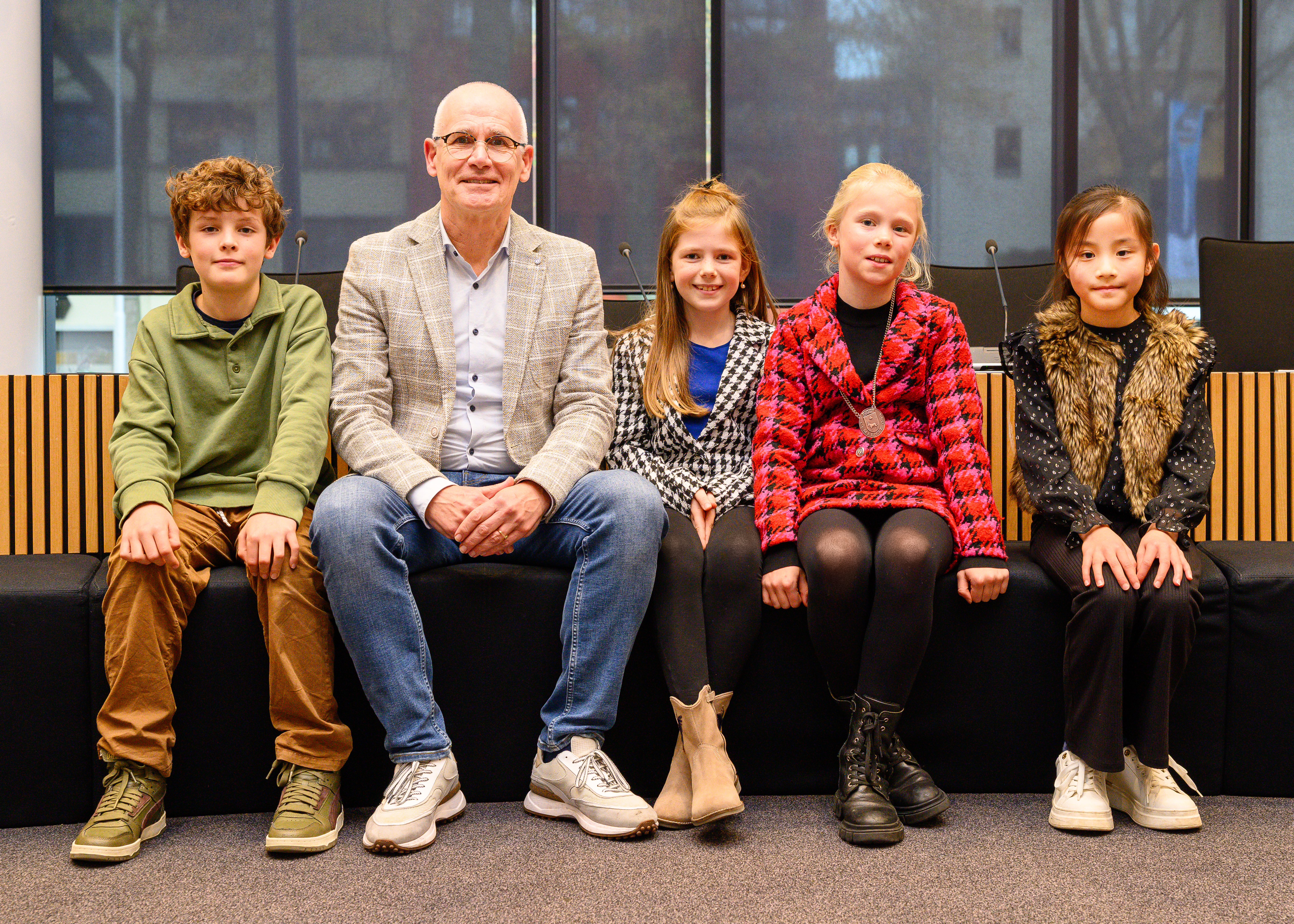 Jeugdcollege in raadzaal in Oss. Teun, wethouder Kees van Geffen, Vera, Julia en Aimee. 