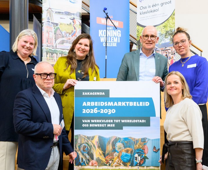 Groep mensen die om een bord met het arbeidsbeleid staan