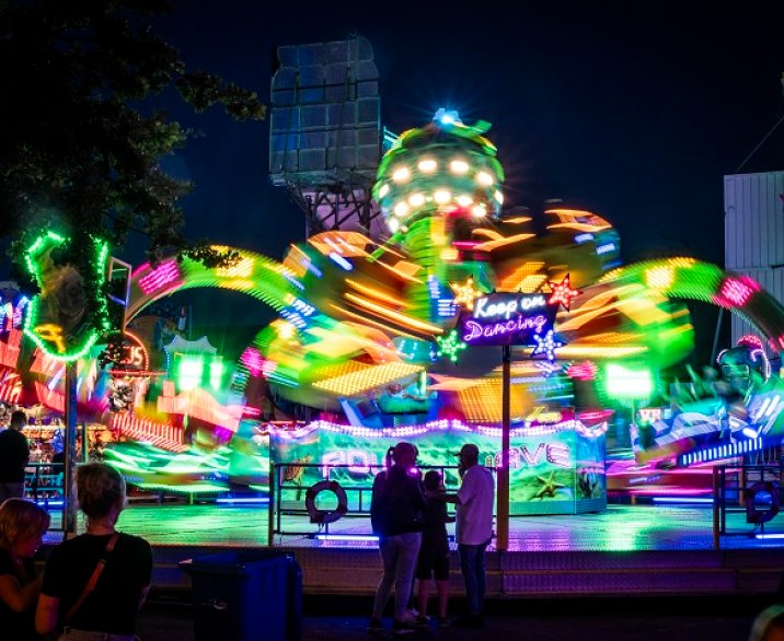 Spinnende kermisattractie in het donker met veel lichtjes